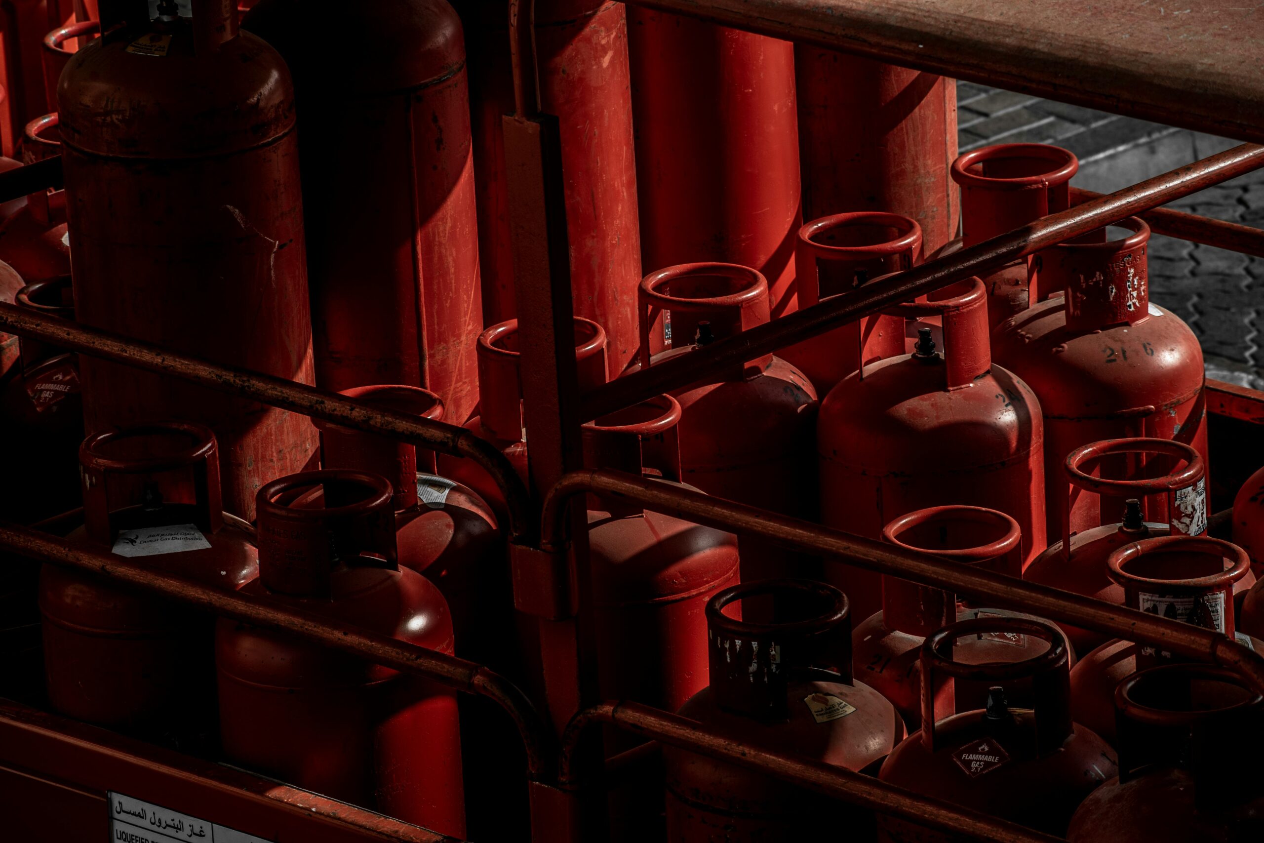 A collection of red gas cylinders stored in an industrial setting, Dubai.